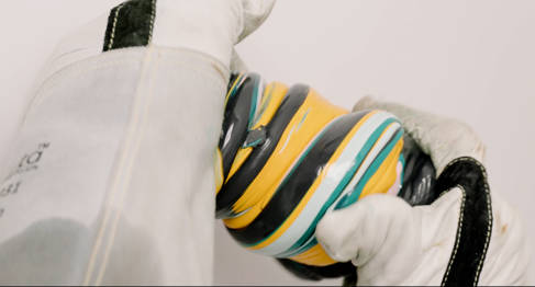 Plastic being squished between two gloved hands
