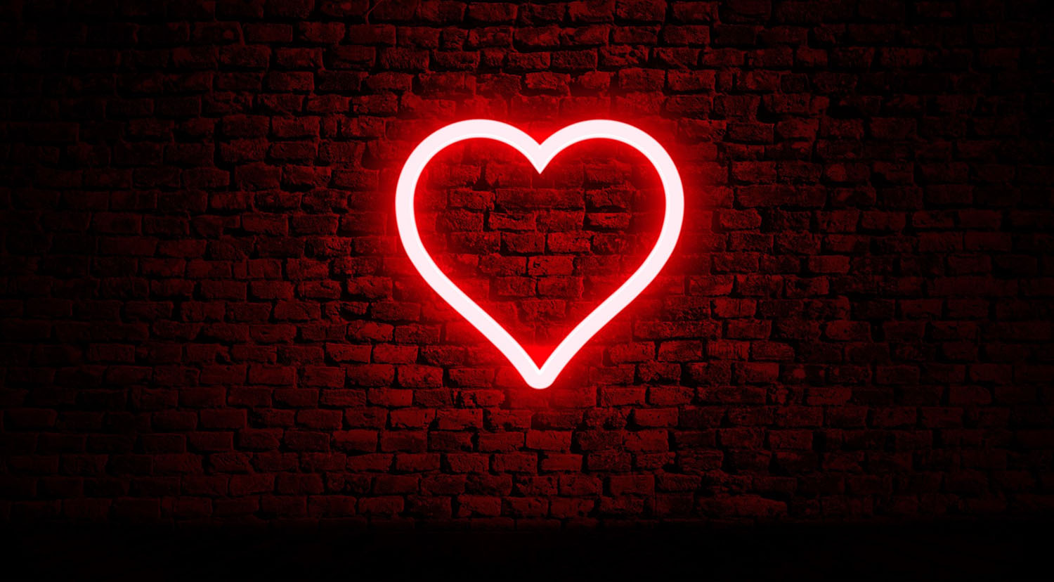 Neon heart on brick wall