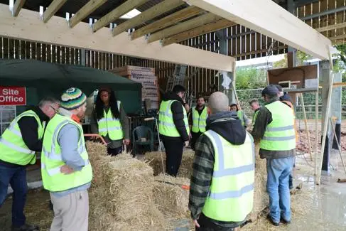 A group of people make straw bales