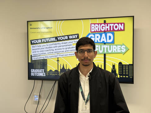 Abdulmalik Alshamari standing in front of tv screen