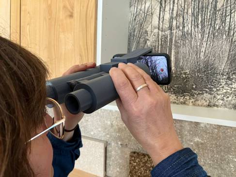 Woman looking through binoculars into augmented reality forest 