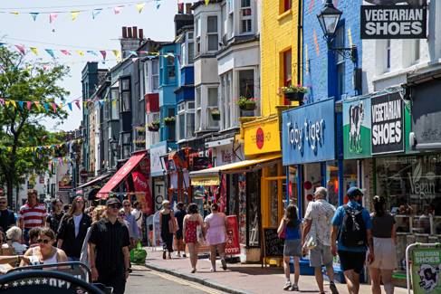 Brighton Lanes on a sunny day. Colourful shop-fronts, bunting and lots people shopping.