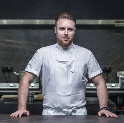 Chef Steven Edwards wearing a white apron