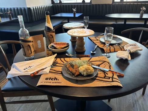 Dining table covered with mats, cutlery, wine holders, and cake stands - all made of cork 