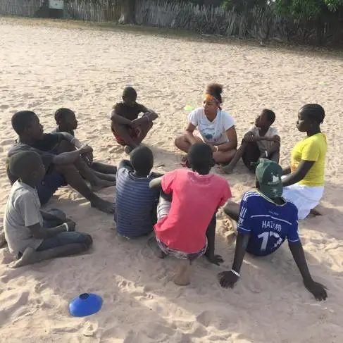 Grace Moore sitting with children in the Gambia
