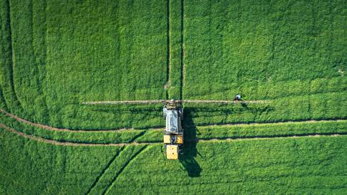 Arial shot of a large agricultural machine in a field