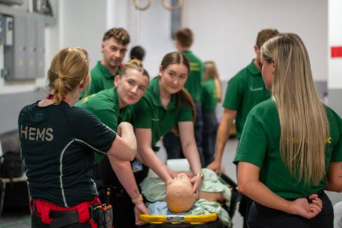 Paramedic students having a CPR demonstration from air ambulance staff 