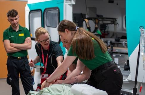 Paramedic students having a CPR demonstration from air ambulance staff