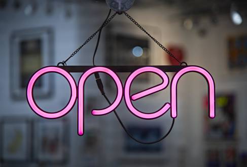 Shop window with neon pink sign reading: open