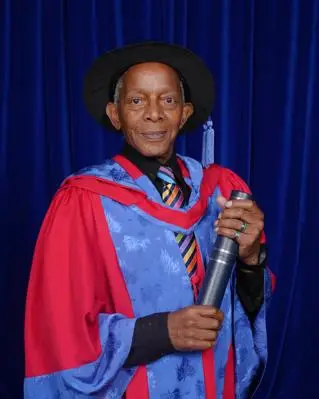Ted Brown in honorary degree gown and smiling