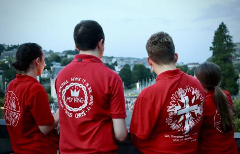 Young people wearing red t-shirts face away from the camera