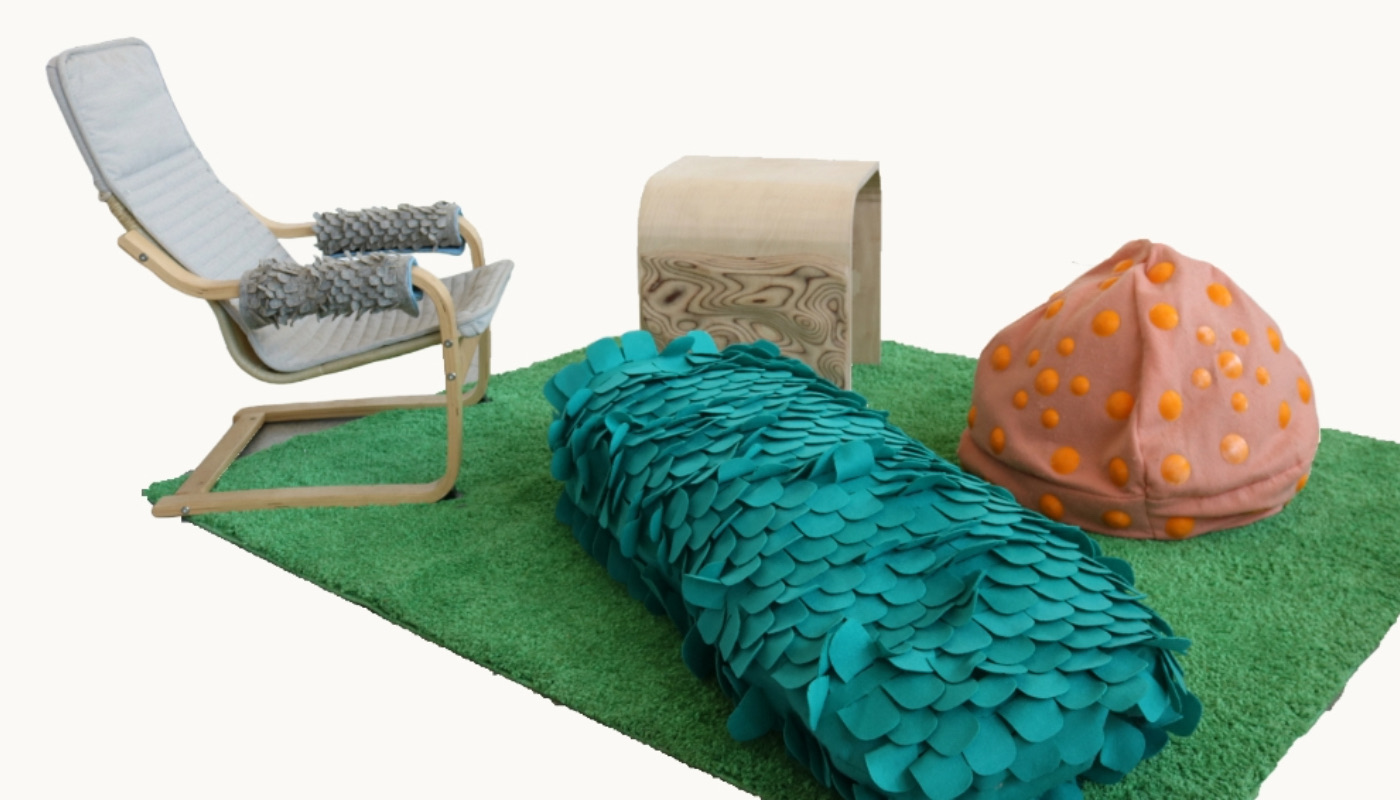 A beanbag, chair, and table on top of a green mat made of fake grass.