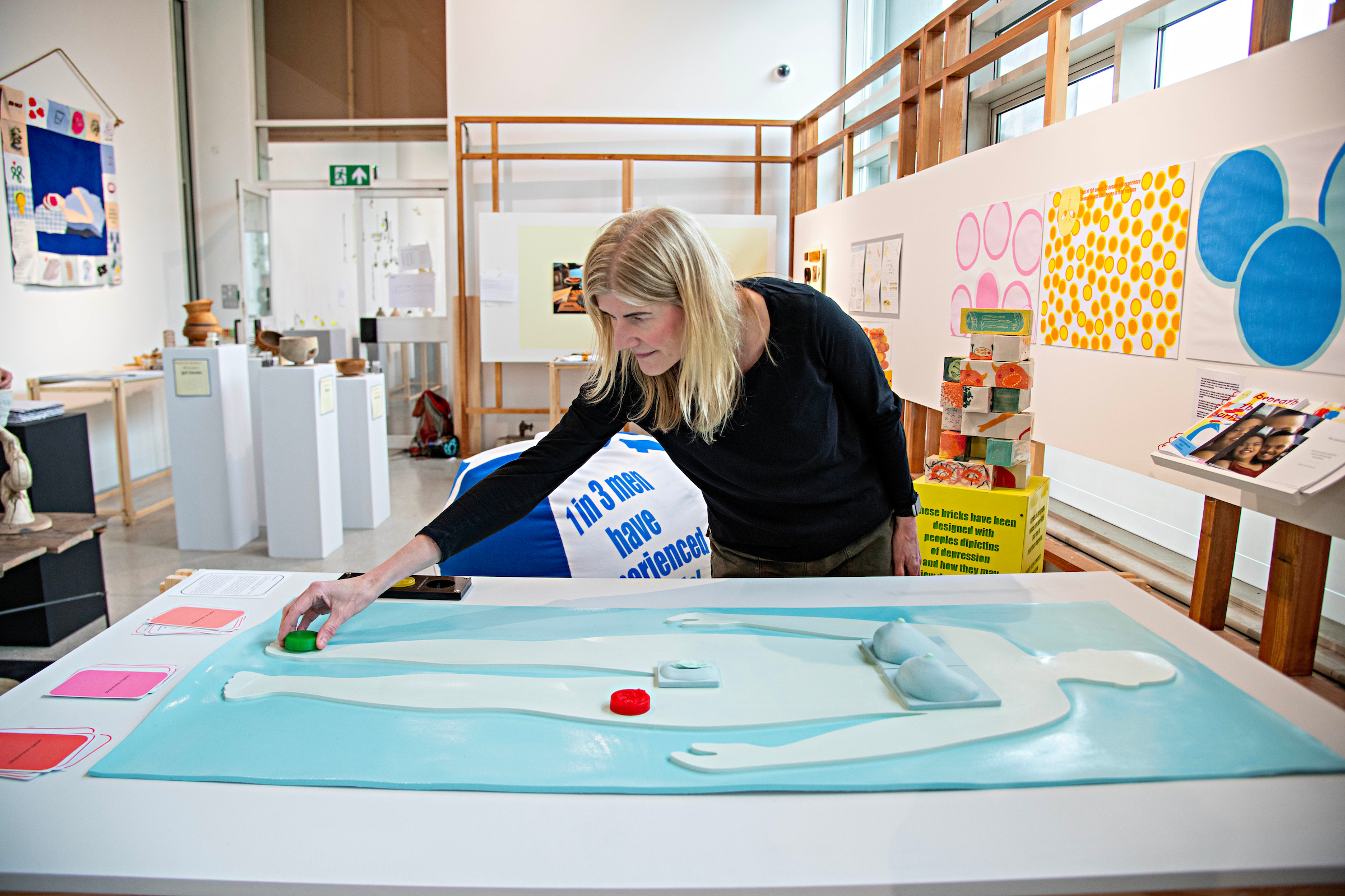 Woman reaching out to touch a blue body mat.