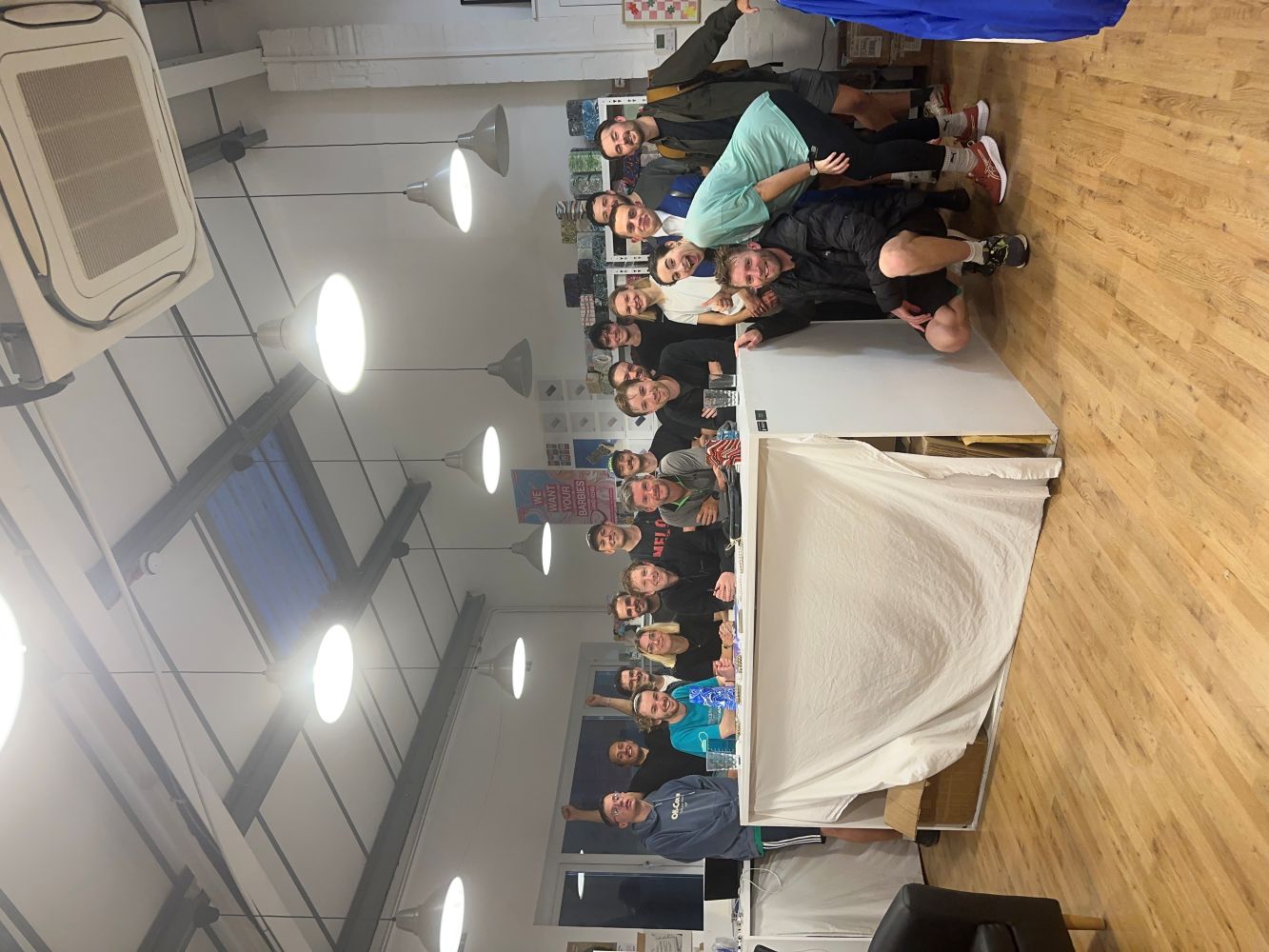 A large group of runners smile indoors