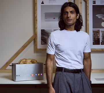 Product design student stands next to a toaster he's designed