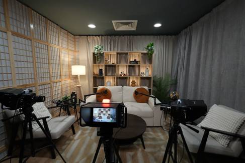 An empty podcast suite with a sofa and recording equipment