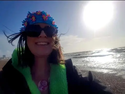 Dr Catherine Kelly smiles on Brighton beach
