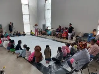 Groups of young people surround a large canvas as part of a Guernica Remaking session