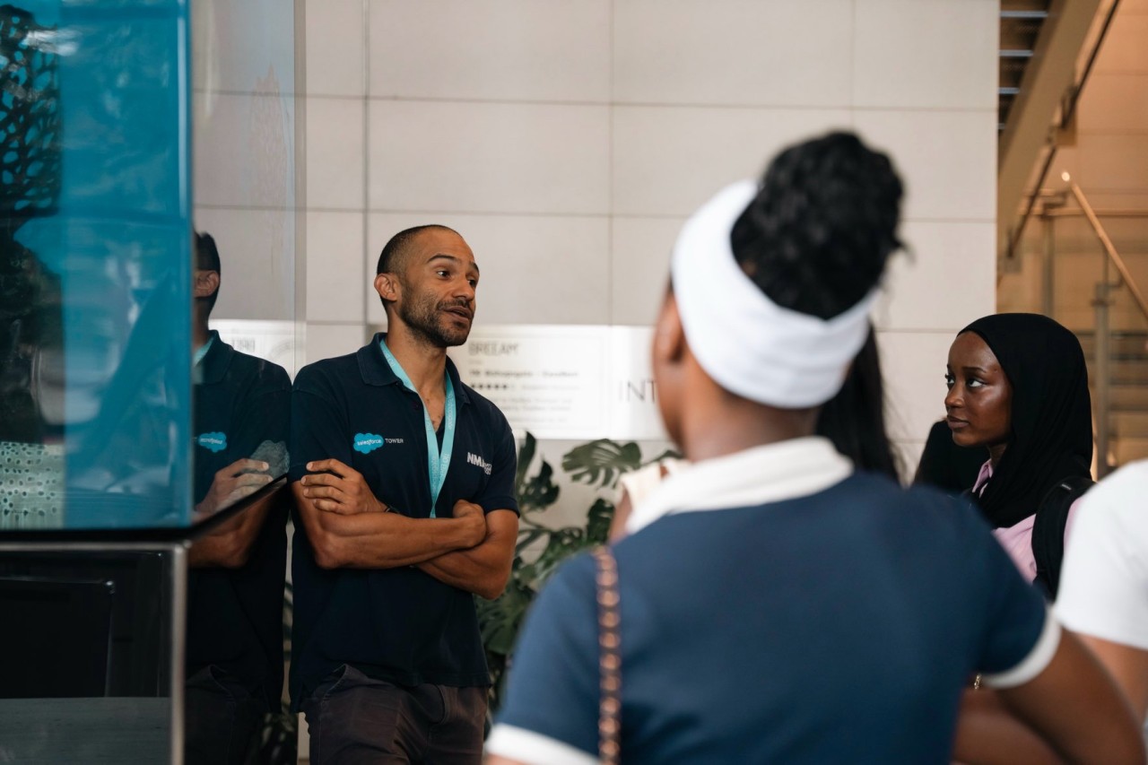 Man speaking to a group of young people in an aquarium