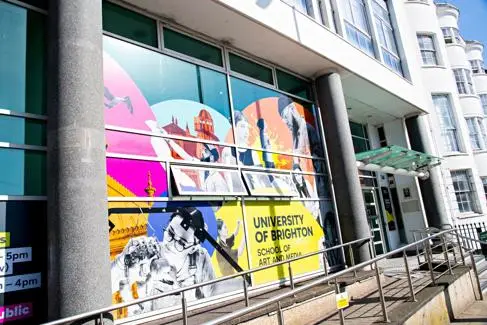 Outside of University of Brighton building with colourful signane on the window