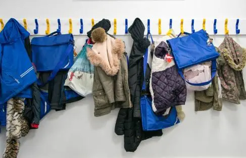 Primary school coat hangers, hung with children's jackets, bags and lunchboxes