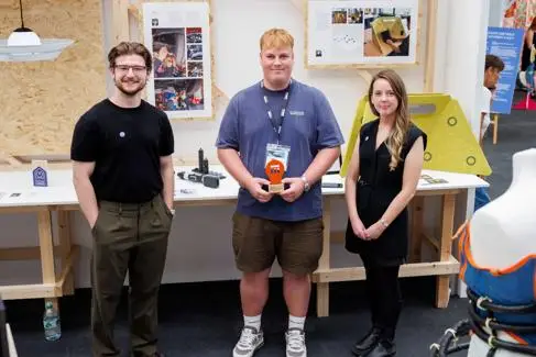 Three students stand having their picture taken