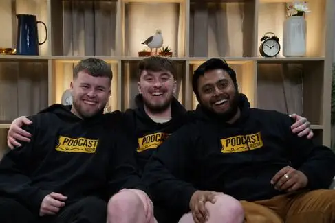 Three young men smile for the camera