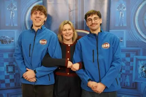 Two young boys in Bargain Hunt outfits have their pictures taken between a blonde woman. They're on Bargain Hunt TV Show