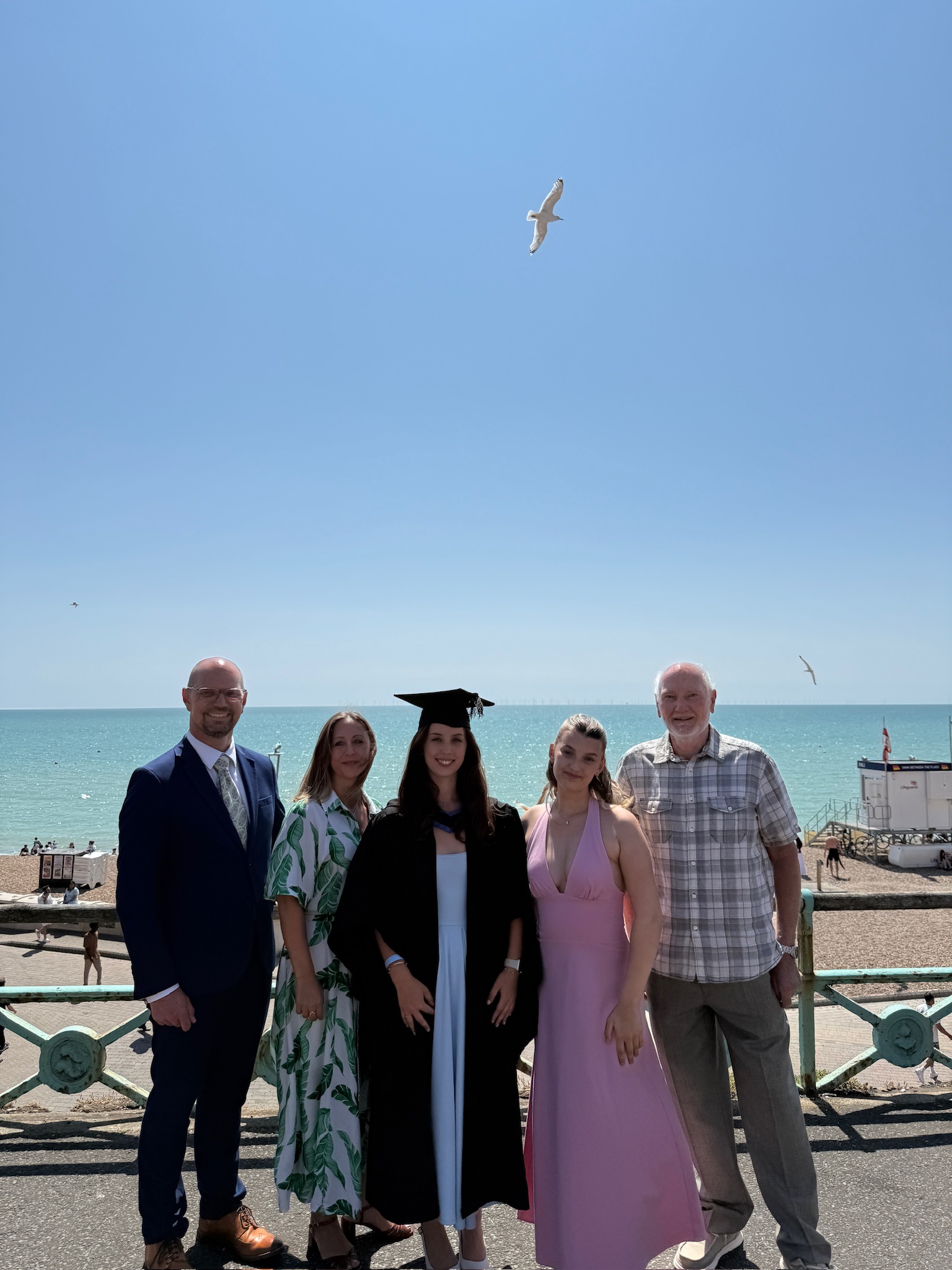 A family pose on Brighton seafront for a graduation picture