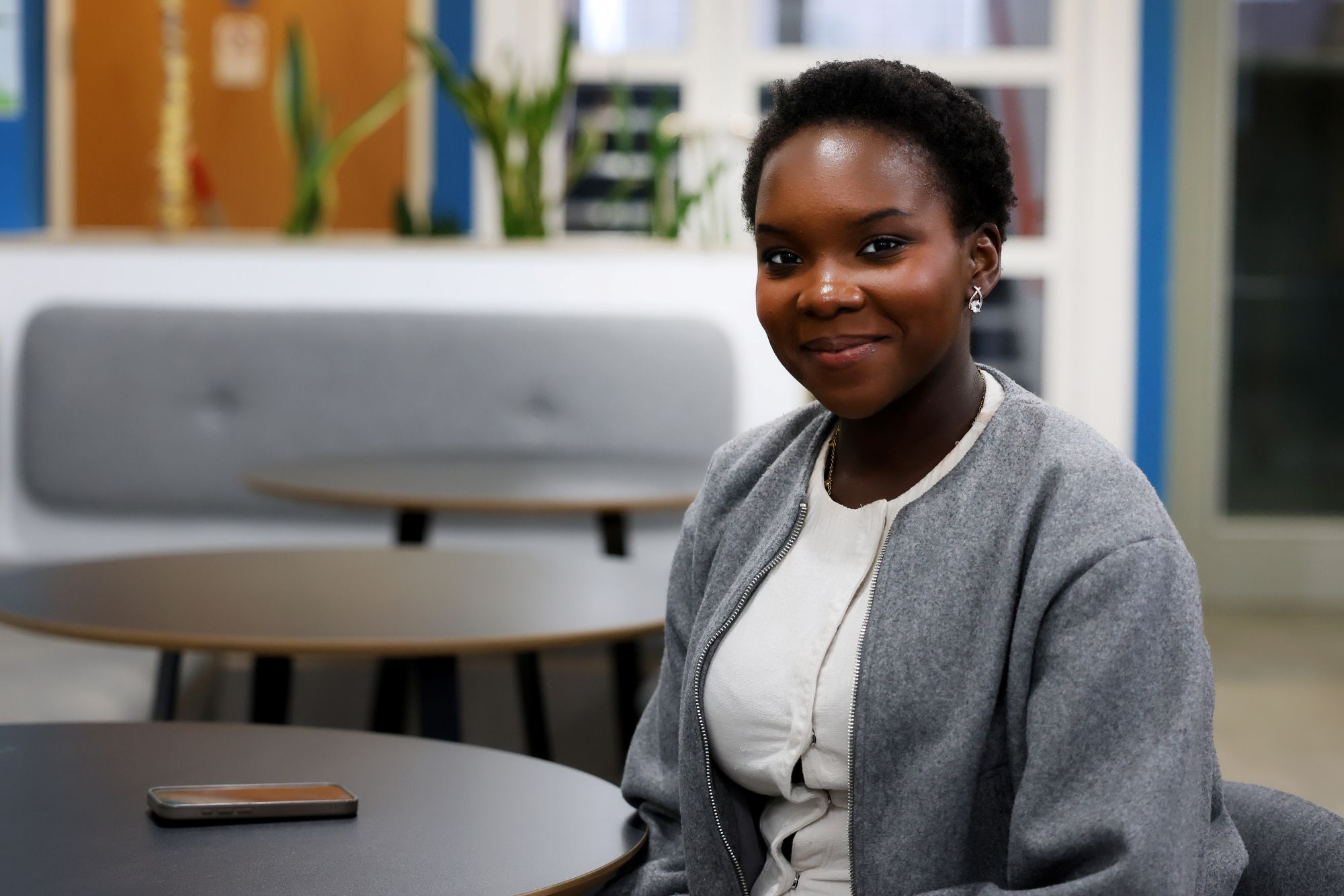 A young Black woman smiles at the camera