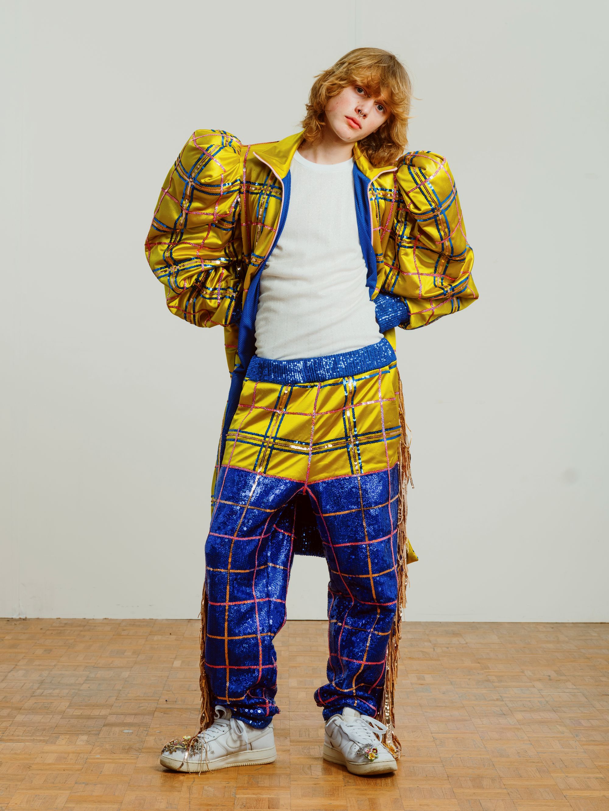 Young man poses in sparkly outfit