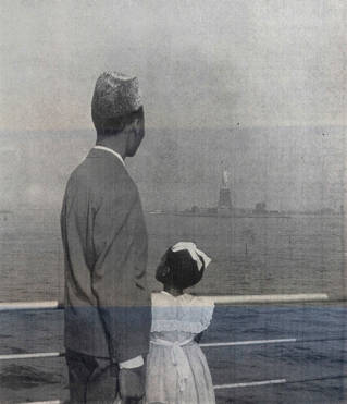 A black and white photo of the back view of a black man and young girl looking at the statue of liberty from a boat