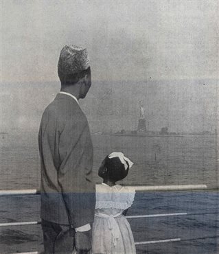Faded and double exposed black and white photograph of a black father and daughter, smartly dressed on the rail of a ship, looking at New York, the Statue of Liberty visible.