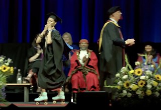 A graduate rollerskating across the stage at graduation
