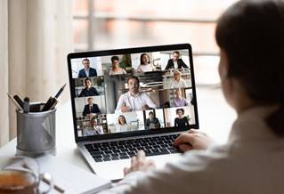 Person using laptop to join video conference with 13 other users
