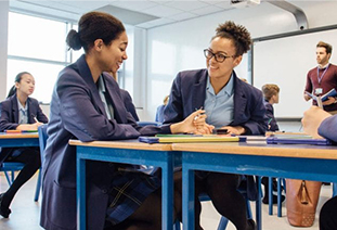 A teacher helping a student in a secondary classroom