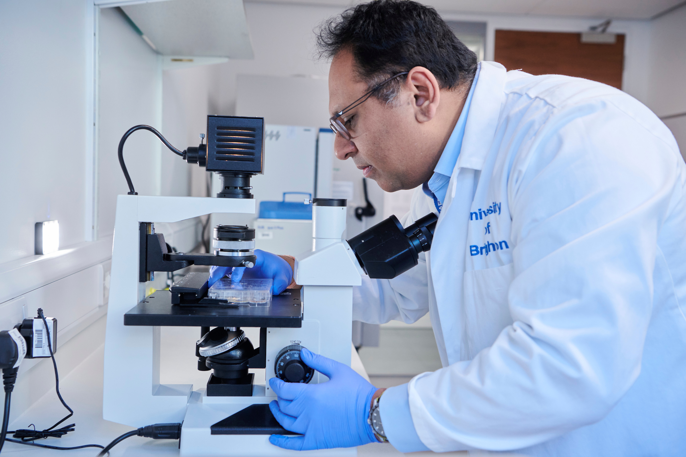 Professor Rameen Shakur placing a sample on a microscope