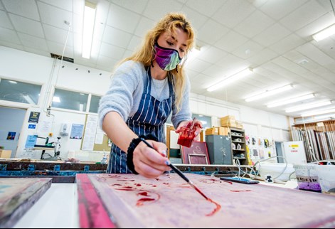 student in mask painting