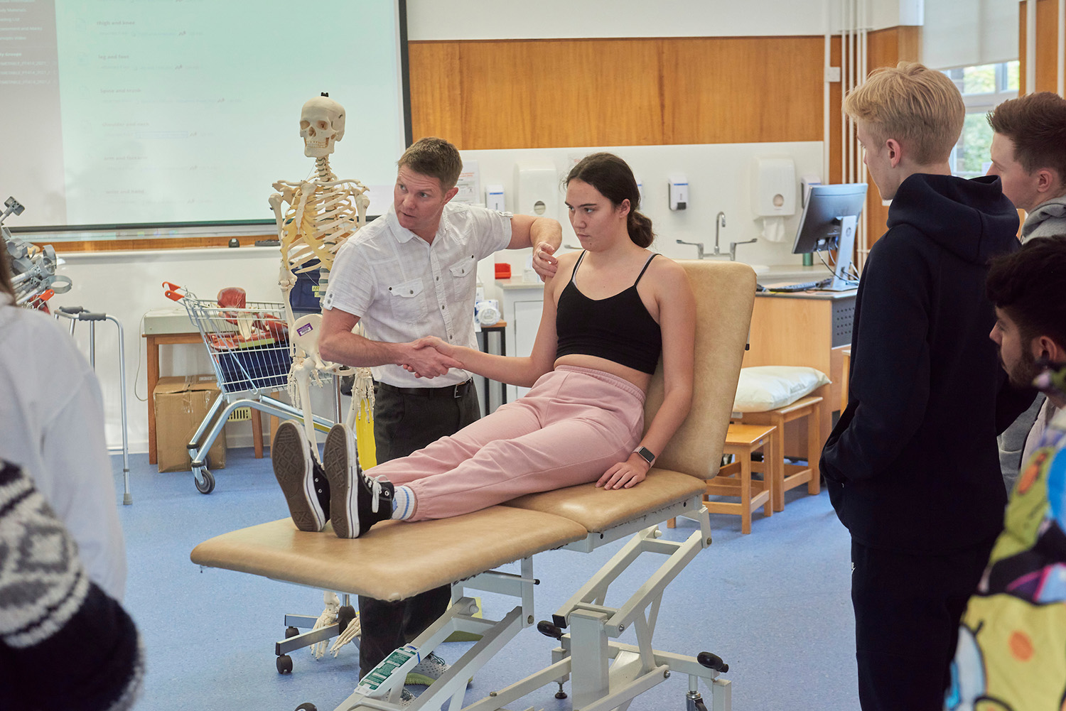 Lecturer demonstrating shoulder movement with a student