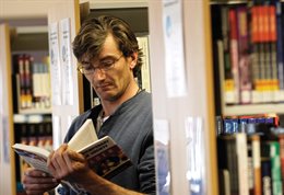 Man reading a book in a library