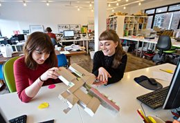 Architecture students examining a model of a building