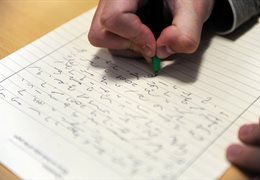 Close-up of a hand writing on paper with a pen