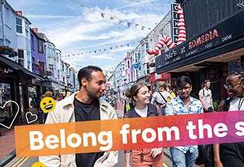 Four students walking in Brighton, with the text 'Belong from the start' overlaid and happy emojis and heart shapes