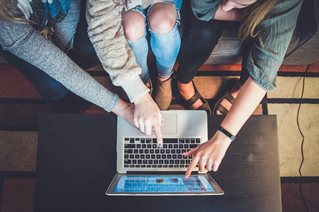 three people using a laptop computer